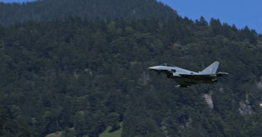 Mollis, İsviçre, 19 Ağustos 2023: Alman Hava Kuvvetleri Eurofighter Typhoon devriyeleri orman arazisi üzerinde devriye geziyor, izleme kapasitesini gösteriyor ve çerçevede kopya alanı mevcut..