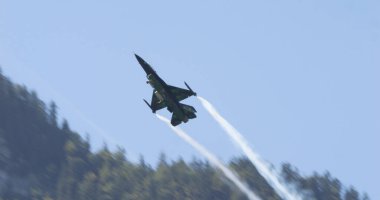 Mollis İsviçre 19 Ağustos 2023: Güneşli Alp Vadisi uçuşunda avcı uçağı. Blue Sky ve Smoke Trails. Uzayı kopyala General Dynamics F-16 Belçika Hava Kuvvetleri Viper Demo 'sunun Savaşan Şahini