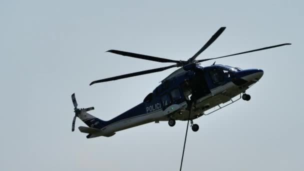 2021年8月15日 スロベニアのマリボル 警察のヘリコプターは 下りる警察官のためのロープを起動するように静止したホバーを維持します スロベニア警察のレオナルド ヘリコプターAw169 — ストック動画