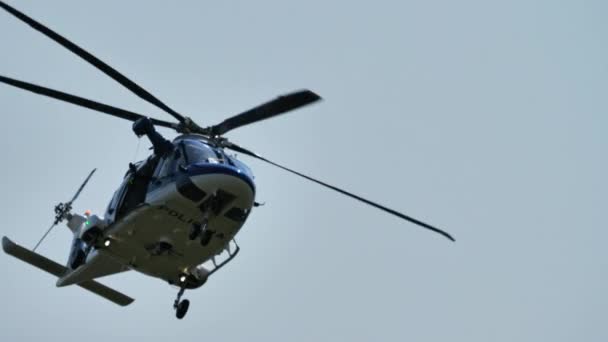 マリボルスロベニア 2021年8月15日 オペレータが負傷回復のためのウィンチロープを下げるように オープンハッチで警察ヘリコプターが浮上します 降下するウィンチ フックのクローズアップ レオナルド Aw169 — ストック動画