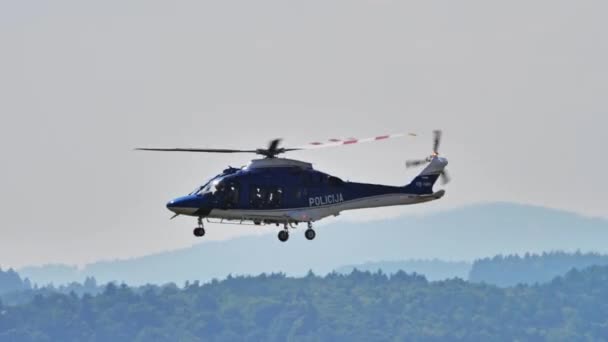 2021年8月15日 スロベニアのマリボル 着陸装置で低高度でパトロールする警察ヘリコプターが拡張され 地域を監督した スロベニア警察のレオナルド ヘリコプターAw169 — ストック動画
