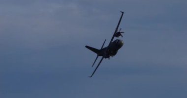 Cerklje ob Krki, Slovenya, 20 Aralık 2023: Sloven Hava Kuvvetleri 'nin Leonardo C-27J Sparta askeri kargo uçağının açık mavi gökyüzünde keskin bir dönüş gerçekleştirmesi.