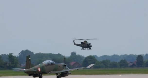 Cerkljeは6月4 2023年6月4日 スロベニア空軍ベル412ヘリコプターは 遠隔で熟練した低高度ターンを実行し 戻ってきます 前景に駐車された航空機 — ストック動画