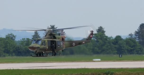 Cerkljeは6月4 2023年6月4日 暗緑色と茶色のカモフラージュ離陸の軍用ヘリコプターを取得し 低高度飛行を行っています アグスタベル 412 スロベニア空軍グリフォン — ストック動画