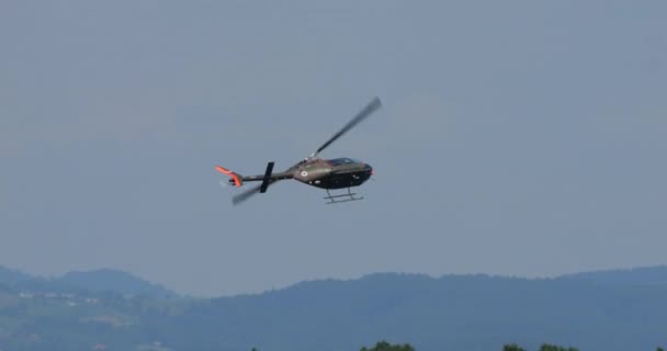 Cerkljeは 2023年6月4日 クルキ スロベニアを手に入れました 敵の捜索作戦に従事した木の上に低高度のパトロールを実施する軍用ヘリコプター スロベニア空軍のベル206 — ストック動画