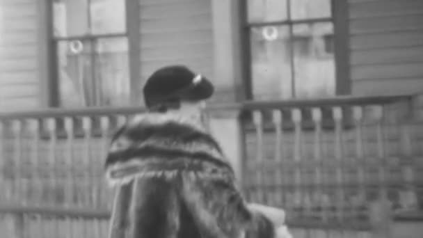 穿着冬衣的微笑的女人步行到朋友家的门廊 在城里聚一聚 度过一个愉快的下午 他们穿的是古典时代的衣服 1930年代的纽约古董画 — 图库视频影像