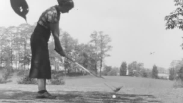 身着传统服装的女高尔夫球手集中在她在一个老高尔夫球场上的秋千上 1930年代纽约高尔夫球场的阳光日 黑白相间的画面 — 图库视频影像