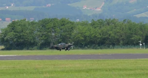 为地面袭击而设计的绿色小型伪装军用螺旋桨飞机降落在机场 显示出行动准备状态和精确度 奥地利空军Pilatus — 图库视频影像