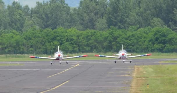 フロントビューでは 滑走路でタクシーに乗り 離陸の準備をしている2機の小型プロペラ駆動トレーニング機を捕獲します スロベニア空軍のZlin 242L — ストック動画