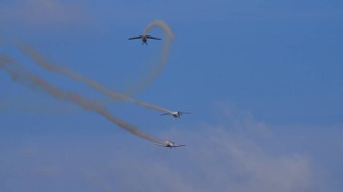 Pula Croatia March 23 2024: Pilatus pc-9 planes from the croatian air force perform a dynamic aerobatic maneuver with smoke trails against a clear blue sky clipart