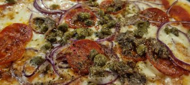 Peynirli nefis bir İtalyan pizzasının yakın çekimi. Domates. Soğan. Ve zeytin. Taze yapılmış ve pişmiş. Geleneksel ev yapımı hamuru ve lezzetli pizza malzemelerini gösteriyor.