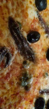 Lezzetli ançüez ve zeytinli pizzanın detaylarını gösteren yüksek çözünürlüklü görüntü.