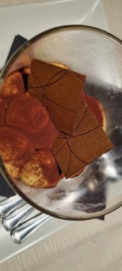 Enfes bir çikolata tatlısı, sanatsal dekorasyonlu, güzel bir yemek ortamında servis ediliyor.