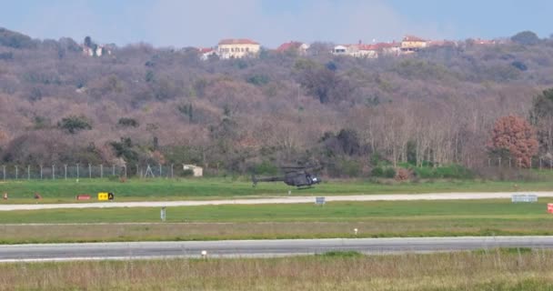 プーラ クロアチア 2024年3月23日 クロアチア空軍タクシーのブラック軍事観測ベルOh 58キオワが離陸に向かう バックグラウンドの緑の丘 — ストック動画