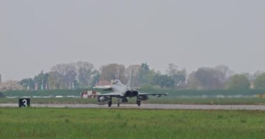Istrana İtalya 5 Nisan 2024: Savaş jeti, gri bir günde Istrana askeri hava üssünde iniş yaptıktan sonra yavaşça pistte taksiler kullanıyor. İtalyan Hava Kuvvetleri 'nden Eurofighter Typhoon