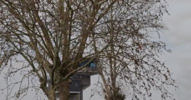 Istrana İtalya 5 Nisan 2024: Havalimanı kontrol kulesi ağaçlarla kısmen gizlenmiş, manzaraya karışıyor.