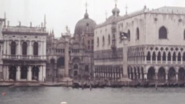 Doge Sarayı 'nın Büyük Mimarisi ve Karmaşık Ayrıntıları ve Zorlayıcı Görünüşü. Ön Tekneler ve İnsanlar 'da. Bulutlu Gökyüzü ve Tarihi Görkem Duyusu. 1950 'lerin Vintage Görüntüsü.