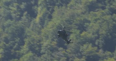 Mollis İsviçre 18 Ağustos 2023: Askeri helikopter uçtuğu vadinin yeşil sarp duvarlarıyla harmanlanırken muharebe manevraları gerçekleştiriyor. Alman ordusundan Eurocopter Tiger 'ın hassasiyeti