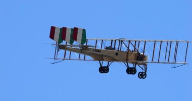 Padova İtalya 22 Haziran 2024: Birinci Dünya Savaşı 'nda mavi gökyüzüne karşı uçan bir Caproni bombardıman uçağının yakın çekimi. İtalyan bayrağı dikey kuyruk yüzeyinde açıkça görülebilir. Tarihi uçağın uçan kopyası..