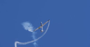 Atina 15 Eylül 2024: Aerobatik planör açık mavi gökyüzüne karşı beyaz duman izleri bırakarak hassas bir manevra gerçekleştirdi. Dinamik hareket ve kopyalama alanı. Swift S-1 L. Bertossio tarafından kullanıldı.. 
