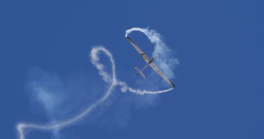 Atina 15 Eylül 2024: Aerobatik planör döngü manevrası yaparak açık mavi gökyüzünde dinamik duman izleri yarattı. Özgürlük kavramı, hassasiyet, hareket. Swift S-1 L. Bertossio tarafından kullanıldı..
