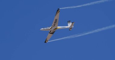 Atina 15 Eylül 2024: Aerobatik planör açık mavi gökyüzünde duman izleriyle süzülüyor. Özgürlük kavramı, hassasiyet, akışkan hareket. Swift S-1 L. Bertossio tarafından kullanıldı..