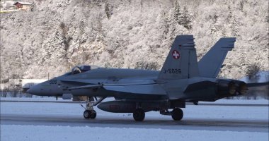 Meiringen Switzerland January 19, 2023: Military jet on a snowy runway during tactical operations for defense and security patrols. Copy space.  clipart