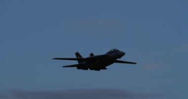 ECTOBER 06, 2024: Montagnana, İtalya: Grumman F-14 Tomcat 'in uzaktan kumandalı bir modeli dramatik, bulutlu bir gökyüzüne doğru kanatları çırpılmış dik bir bankacılık dönüşünü gerçekleştirirken siluetlendi.