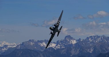 30 Mayıs 2025 Hoher Kasten İsviçre: Douglas DC-3 C-47 Skytrain askeri taşımacılık uçağı, D-Day istila çizgileriyle, görkemli İsviçre Alpleri üzerinde dik bir bankacılık manevrası gerçekleştirdi..