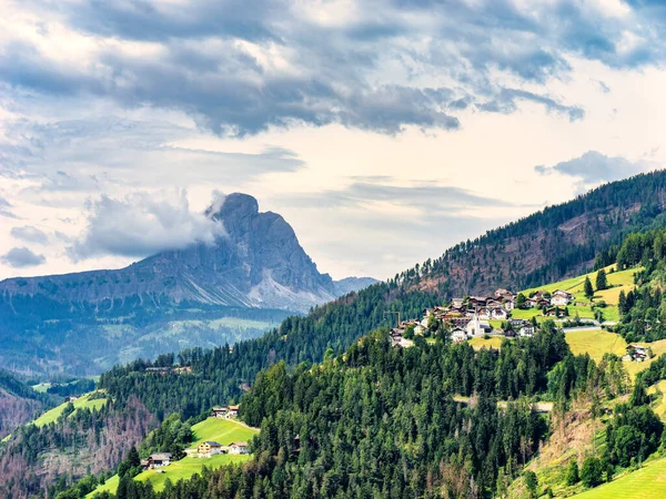 The vertical north face of the dolomitic peak Sass da Putia dominates village of Rina in Val Badia, Alto Adige, Italy. High quality photo