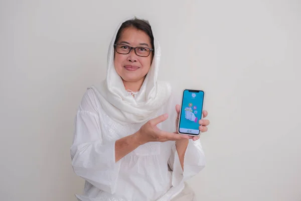 2023年2月20日 インドネシアの女性がヨガジャカルタのスマートフォンで Satsu Sehat プログラムを見せている — ストック写真
