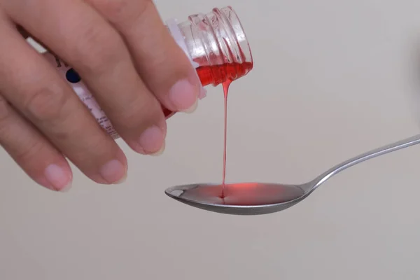 closeup shot of cough syrup poured into a spoon