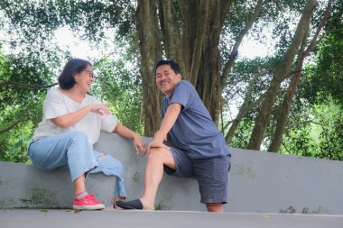 Erkek ve kadın parkta uzun bir yürüyüşten sonra mola veriyorlar.