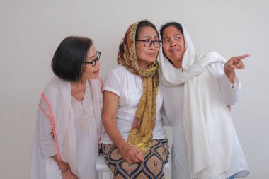 Üç kadın bir araya geliyor, bir toplantıda diğer insanları utandırmakla meşgul.