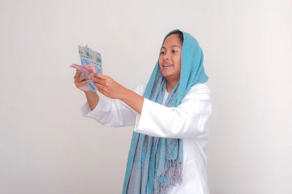 ラマダーン月のお祝いにお金を受け取るのをとても喜んでいるアジア系イスラム教徒の女の子 — ストック写真