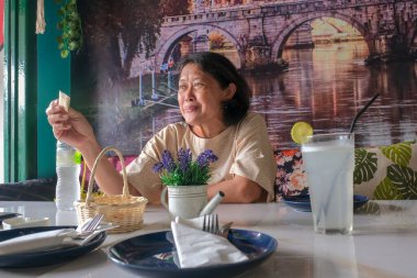 Restoran masasında aperatif yiyen bir kadın.