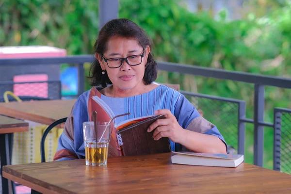 Asijská Žena Sedí Doma Balkóně Čtení Knihy Sklenicí Citrónového Čaje — Stock fotografie