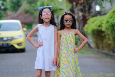 Oyuncak güneş gözlükleriyle poz veren iki küçük Asyalı kız.