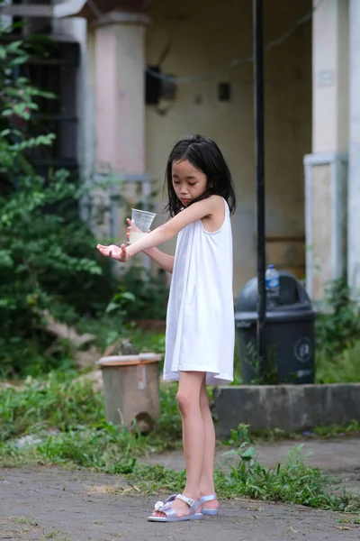 Милая Маленькая Азиатка Стоящая Одна Заднем Дворе Пьет Воду Пластиковой — стоковое фото
