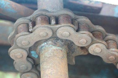 Evin arka planında paslı metal bir zincir var..