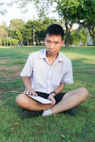 Jovem Estudante Sentado Grama Lendo Livro — Fotografia de Stock
