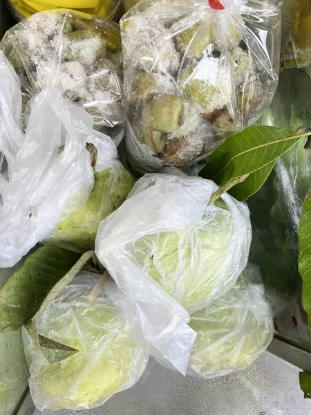 plastic bags with green guava in food shop