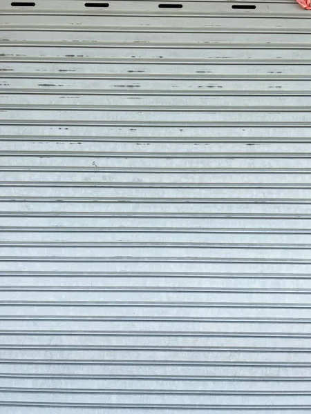 白と青の縞模様の古い金属製のフェンス — ストック写真
