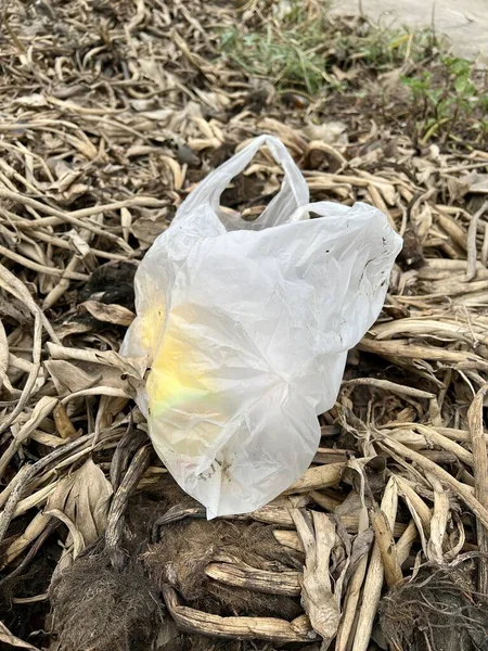 plastic bag with garbage on the ground