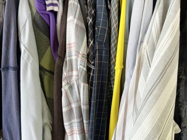 Farklı tişörtlerden oluşan bir askıya yakın plan.