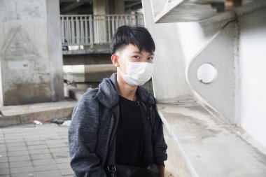young man in a protective mask and a black surgical cap and a face of a medical masks