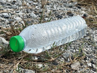 Çimlerin üzerinde su olan plastik şişe.