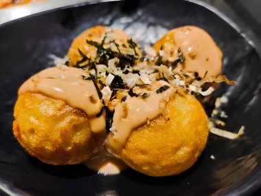 Soslu ve yumurtalı kızarmış Takoyaki.