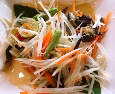 Lezzetli Asya yemekleri ve papaya salatasının yakın görüntüsü.