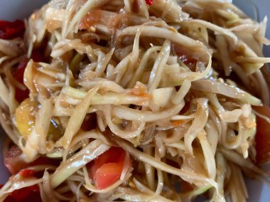 Lezzetli Asya yemekleri ve papaya salatasının yakın görüntüsü.